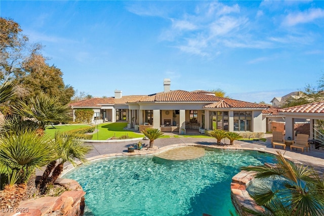 back of house with a chimney, stucco siding, a pool with connected hot tub, a patio area, and a tiled roof