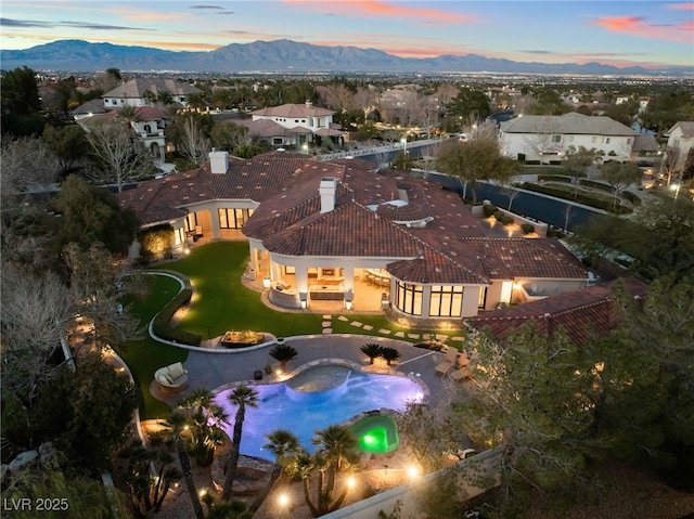 aerial view at dusk featuring a residential view and a mountain view