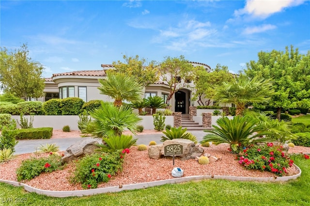 mediterranean / spanish home with a tile roof and stucco siding