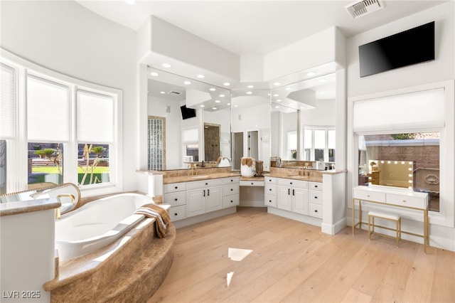 bathroom with a garden tub, recessed lighting, visible vents, vanity, and hardwood / wood-style floors