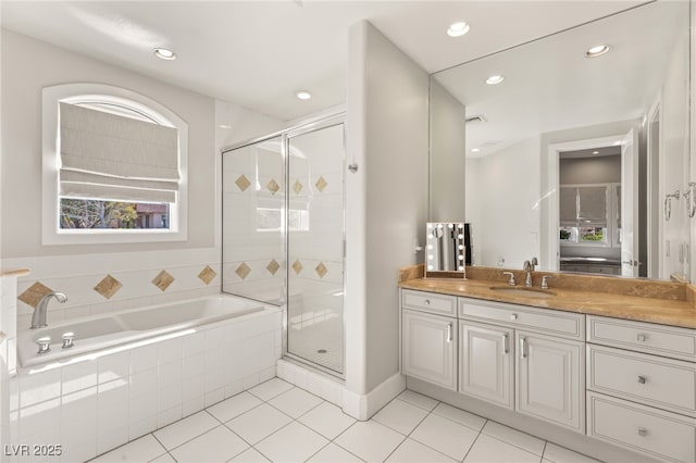 bathroom featuring a stall shower, tile patterned flooring, a bath, and vanity