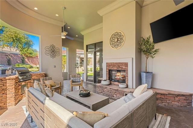 view of patio / terrace with ceiling fan, an outdoor kitchen, an outdoor living space with a fireplace, and grilling area