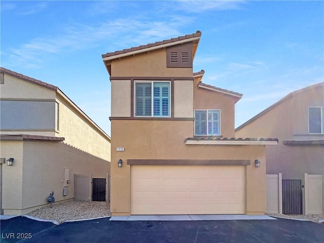 view of front of property featuring a garage, a tile roof, fence, and stucco siding