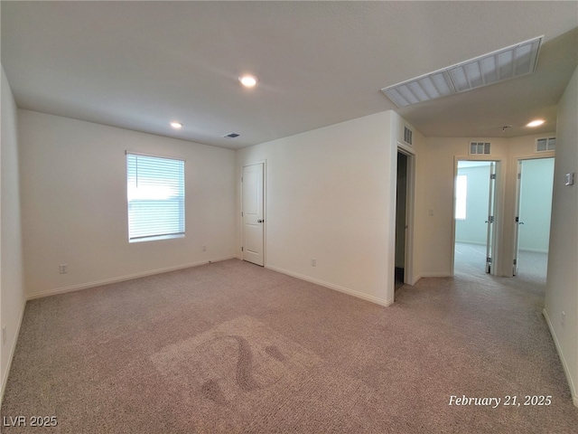 unfurnished room featuring light carpet, visible vents, and baseboards