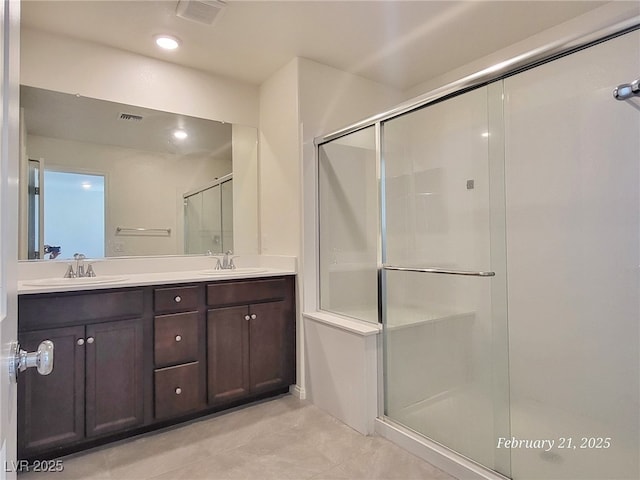 full bath with double vanity, a sink, and visible vents