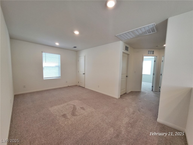 empty room with recessed lighting, visible vents, light carpet, and baseboards