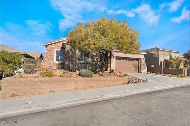 view of front of house featuring a garage, stone siding, concrete driveway, and stucco siding