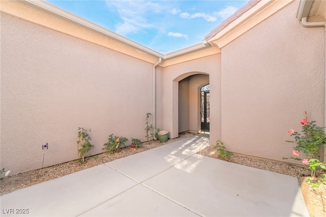 entrance to property with a patio area and stucco siding