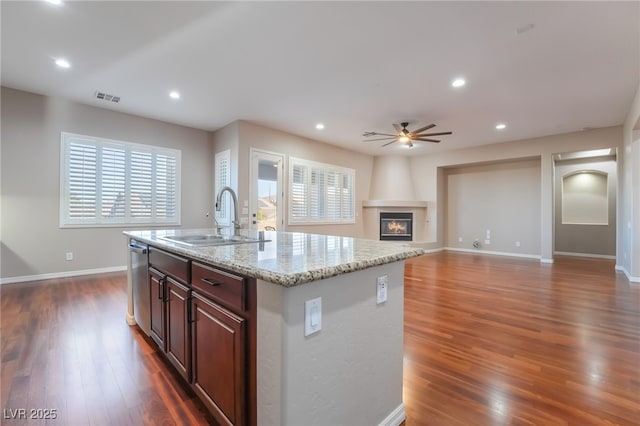 kitchen with a fireplace, visible vents, dark wood-type flooring, a sink, and dishwasher