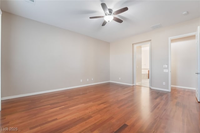 unfurnished bedroom with ceiling fan, ensuite bath, wood finished floors, and baseboards