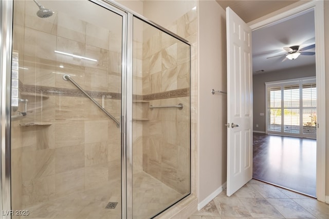 bathroom featuring ceiling fan, a shower stall, and baseboards