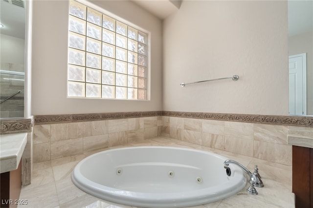 bathroom with a jetted tub and vanity