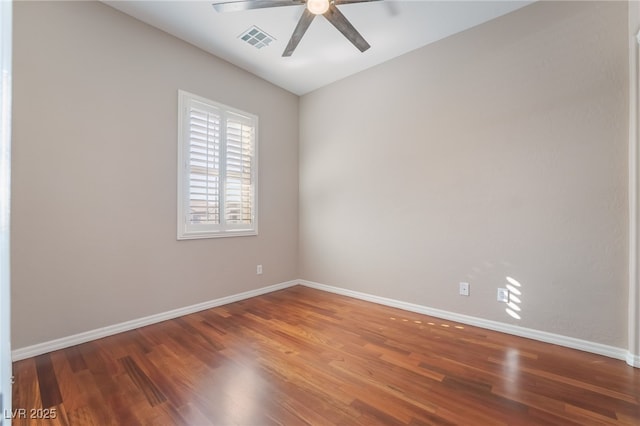 empty room featuring ceiling fan, wood finished floors, visible vents, and baseboards