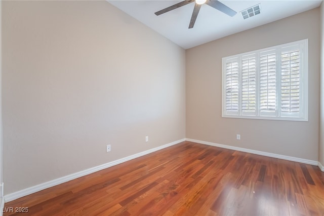 spare room featuring a ceiling fan, wood finished floors, visible vents, and baseboards