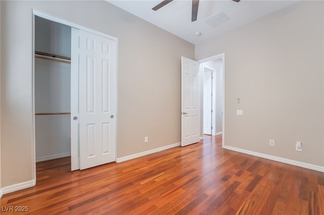 unfurnished bedroom featuring ceiling fan, a closet, baseboards, and wood finished floors