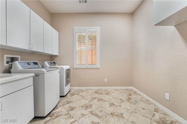 clothes washing area featuring washer and dryer, cabinet space, visible vents, and baseboards