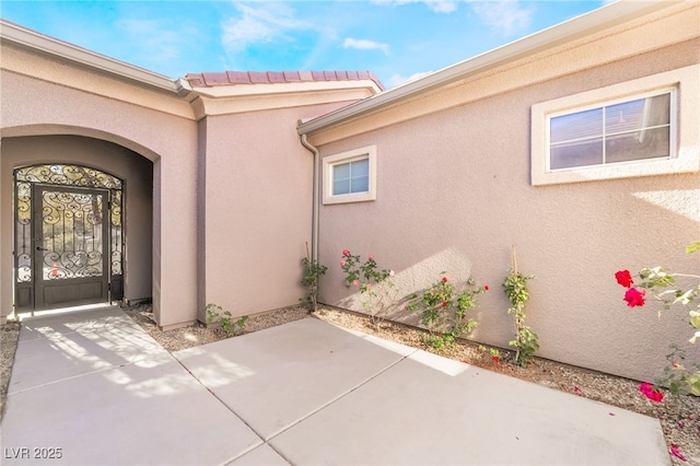 property entrance with a patio area and stucco siding