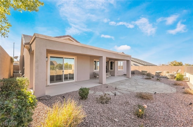 back of property featuring a patio, central AC unit, a fenced backyard, and stucco siding