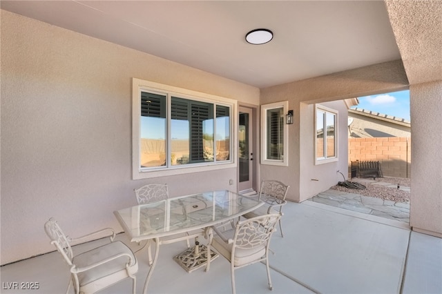 view of patio with outdoor dining space and fence