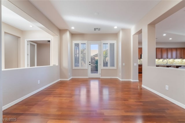 interior space featuring baseboards, wood finished floors, and recessed lighting