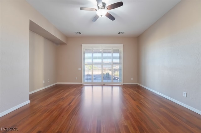 spare room featuring visible vents, baseboards, and wood finished floors