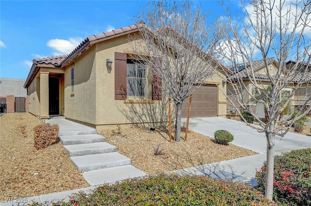 view of front of property with an attached garage, a tiled roof, concrete driveway, and stucco siding