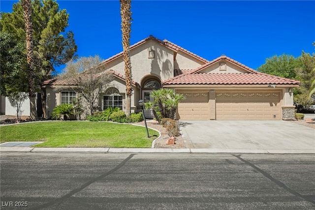 mediterranean / spanish-style house with a garage, concrete driveway, a front lawn, and stucco siding