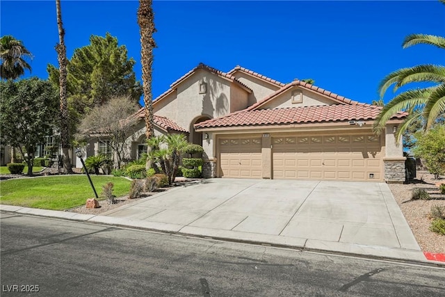 mediterranean / spanish house with driveway, stucco siding, a tile roof, an attached garage, and a front yard