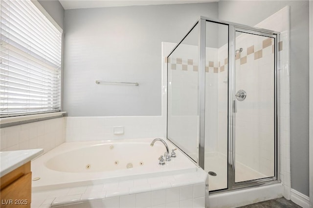 full bath featuring a stall shower, a jetted tub, and vanity