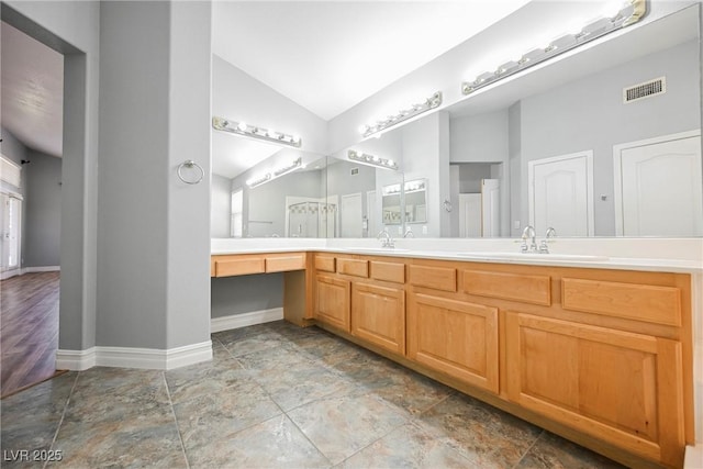 full bath with vaulted ceiling, double vanity, a sink, and visible vents