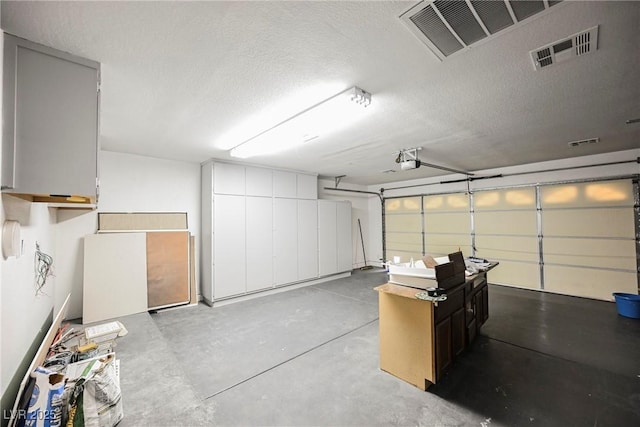 garage featuring visible vents and a garage door opener