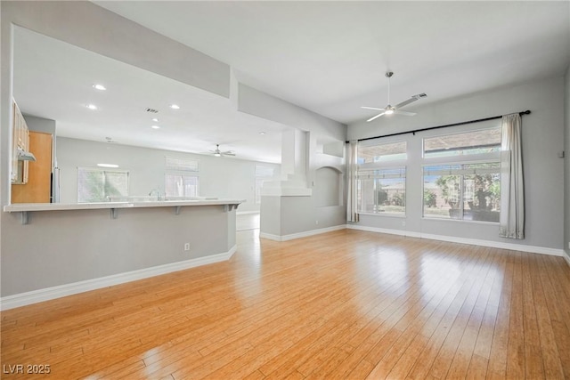 unfurnished living room featuring recessed lighting, light wood-type flooring, a ceiling fan, and baseboards