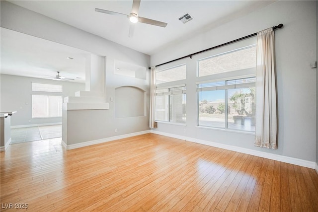 unfurnished living room featuring ceiling fan, light wood finished floors, visible vents, and baseboards