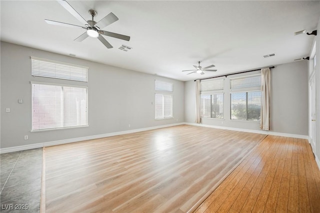 unfurnished living room with a ceiling fan, light wood-type flooring, visible vents, and baseboards