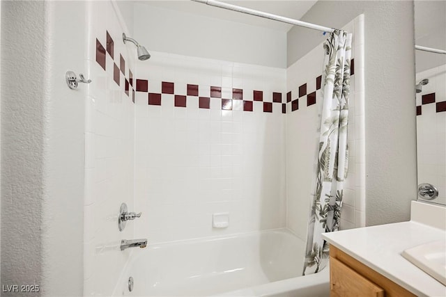 full bathroom featuring shower / bath combo, a textured wall, and vanity