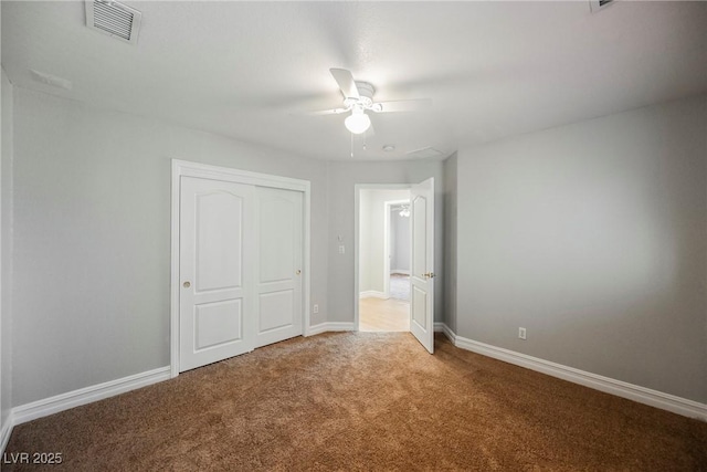 unfurnished bedroom with carpet floors, baseboards, visible vents, and a closet