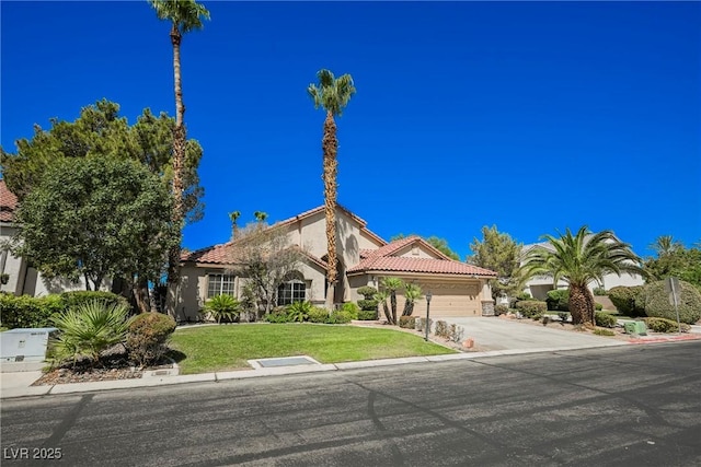 mediterranean / spanish-style home featuring stucco siding, concrete driveway, a front yard, a garage, and a tiled roof