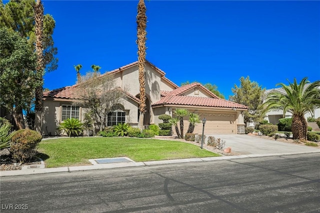 mediterranean / spanish home with a garage, concrete driveway, a front lawn, and stucco siding