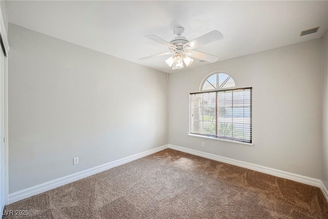 carpeted empty room with baseboards, visible vents, and ceiling fan