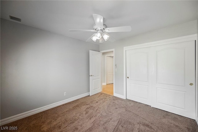 unfurnished bedroom with ceiling fan, light colored carpet, visible vents, baseboards, and a closet