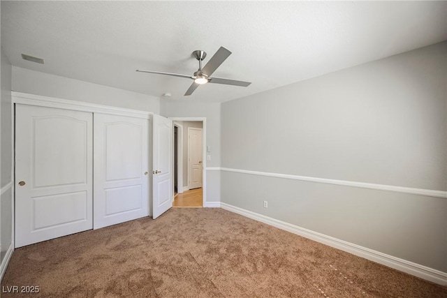 unfurnished bedroom with a closet, visible vents, a ceiling fan, light carpet, and baseboards