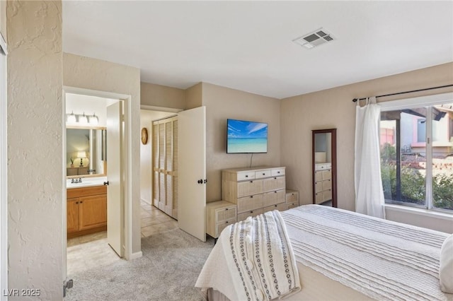 bedroom with light colored carpet, visible vents, and connected bathroom