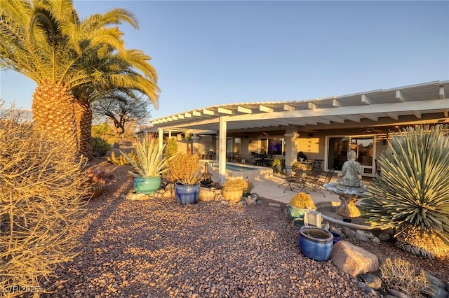 back of property with a pergola and a patio