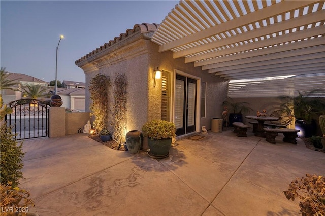 patio terrace at dusk with a gate and a pergola