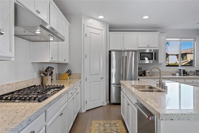 kitchen featuring white cabinets, stainless steel appliances, under cabinet range hood, a sink, and recessed lighting