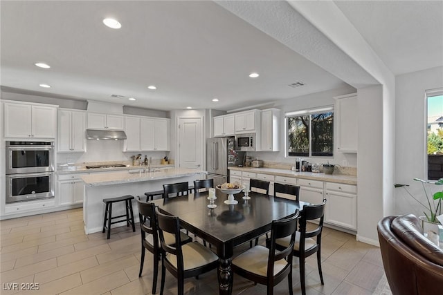 dining space featuring baseboards, visible vents, and recessed lighting