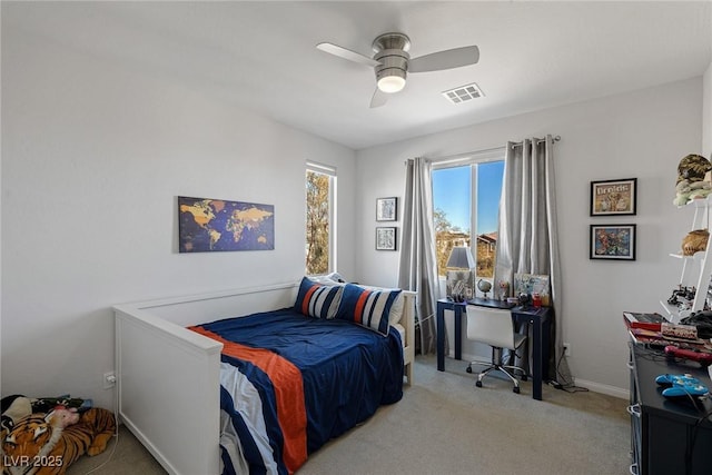 bedroom with baseboards, a ceiling fan, visible vents, and light colored carpet