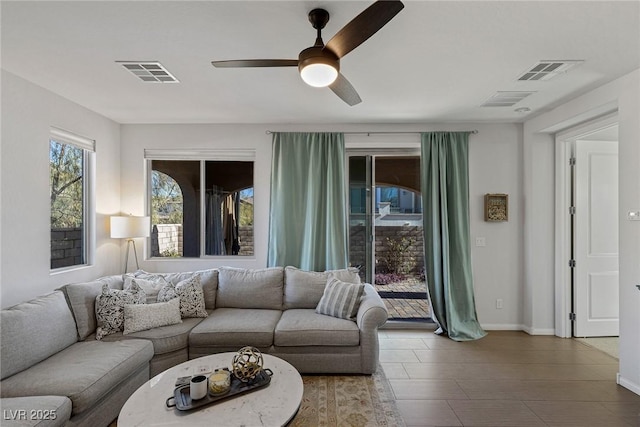 living room featuring baseboards, visible vents, and a ceiling fan