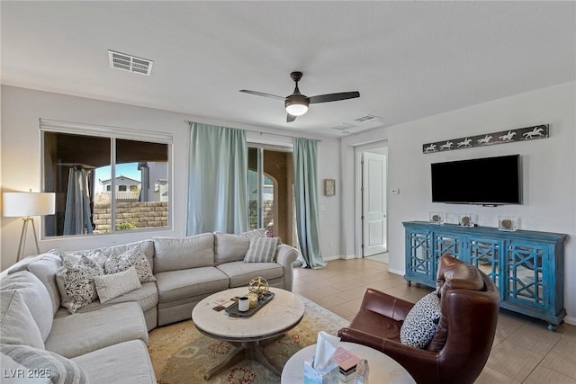 living area featuring ceiling fan, plenty of natural light, and visible vents