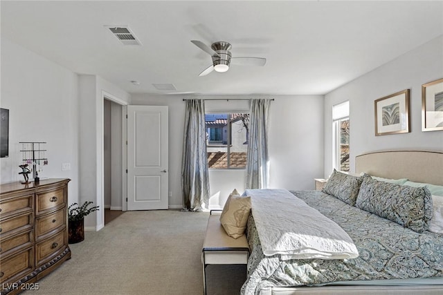 bedroom featuring baseboards, visible vents, a ceiling fan, and light colored carpet